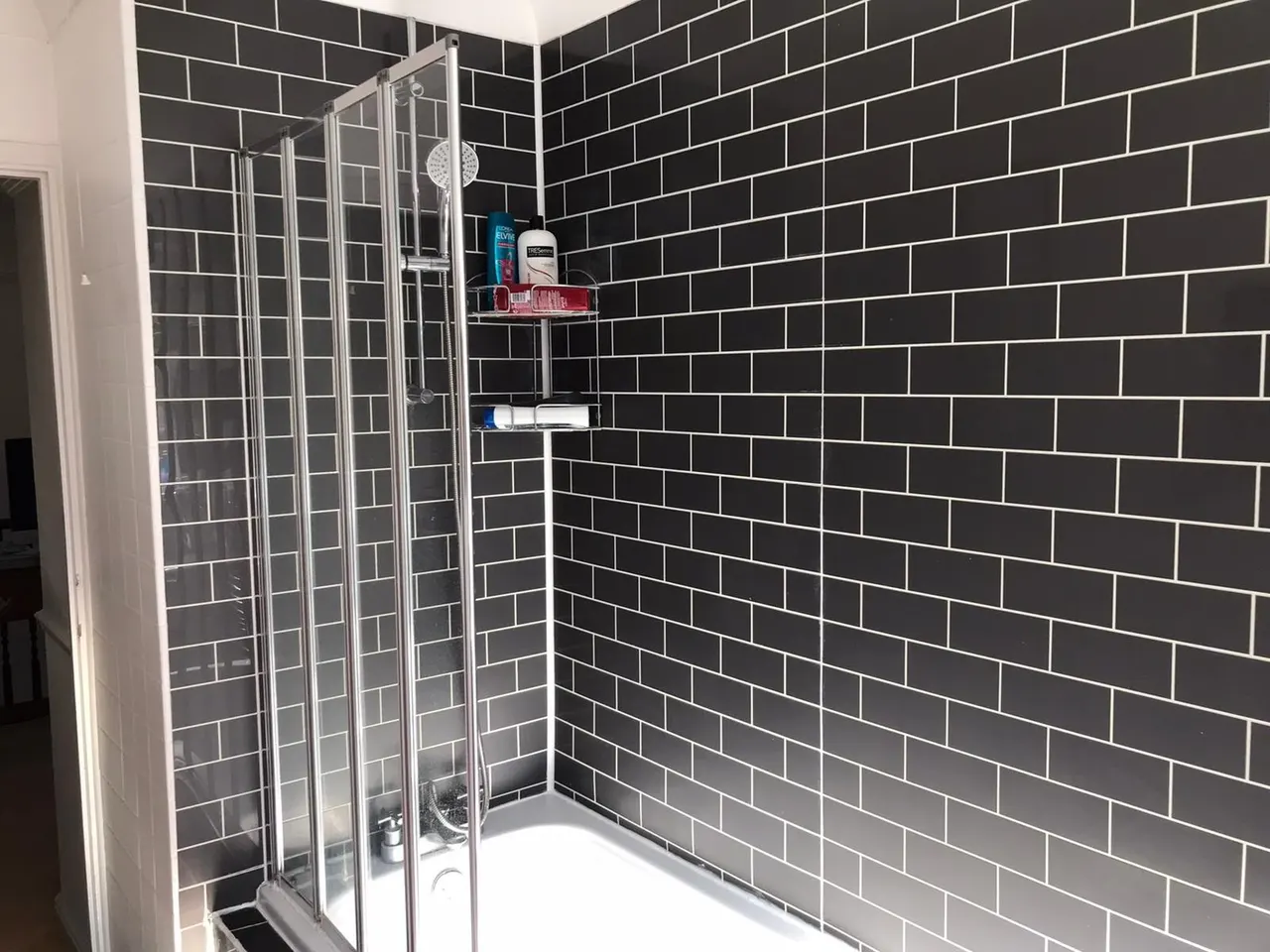 Bathroom renovation in London: before photo of dark subway-tiled bath area
