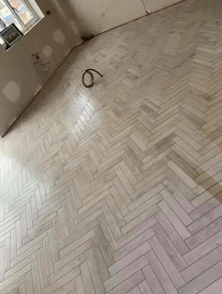Floor and wall tiling in London: light herringbone floor tiles in progress