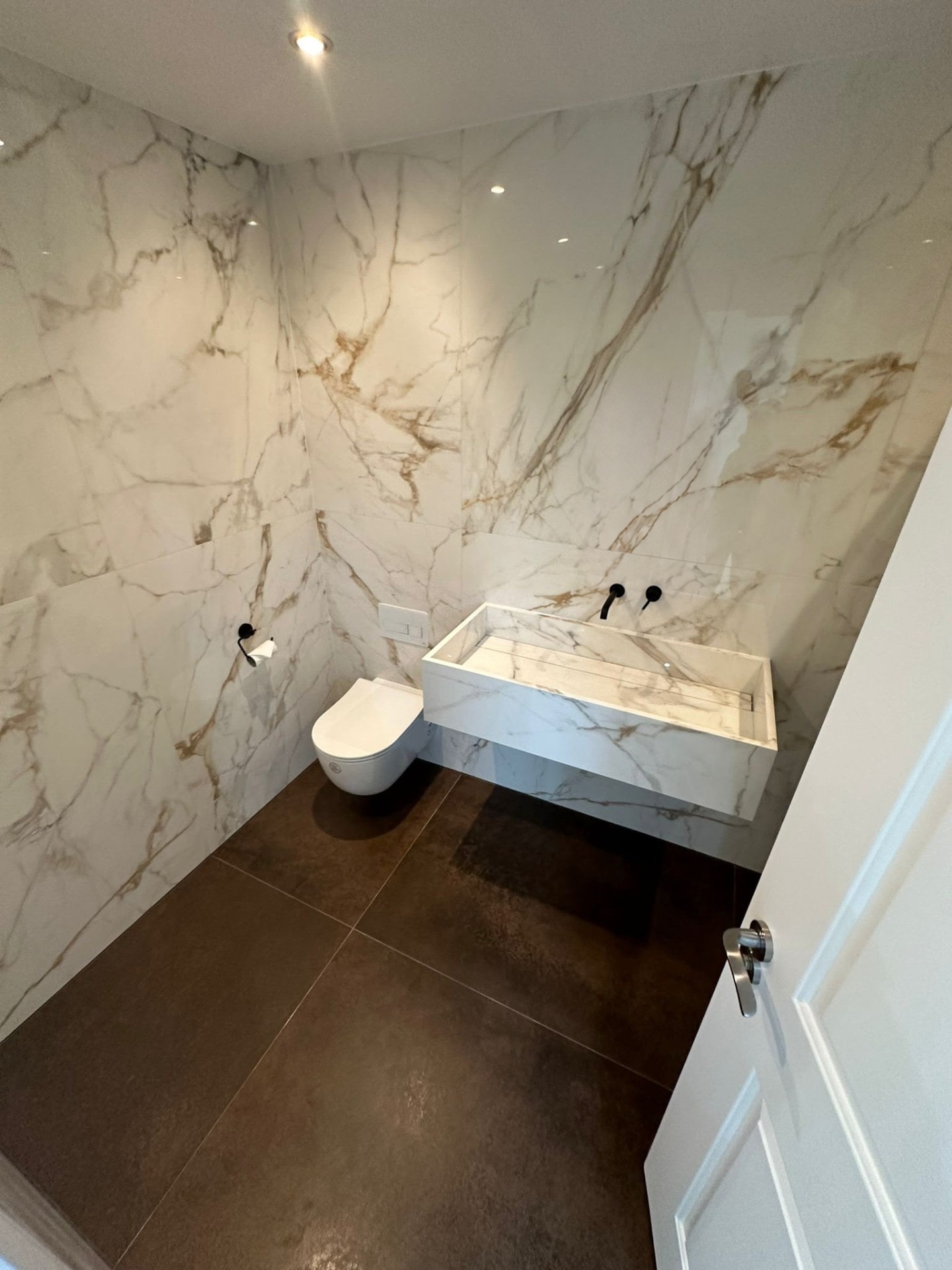 Marble-effect bathroom with floating basin by Tilermate