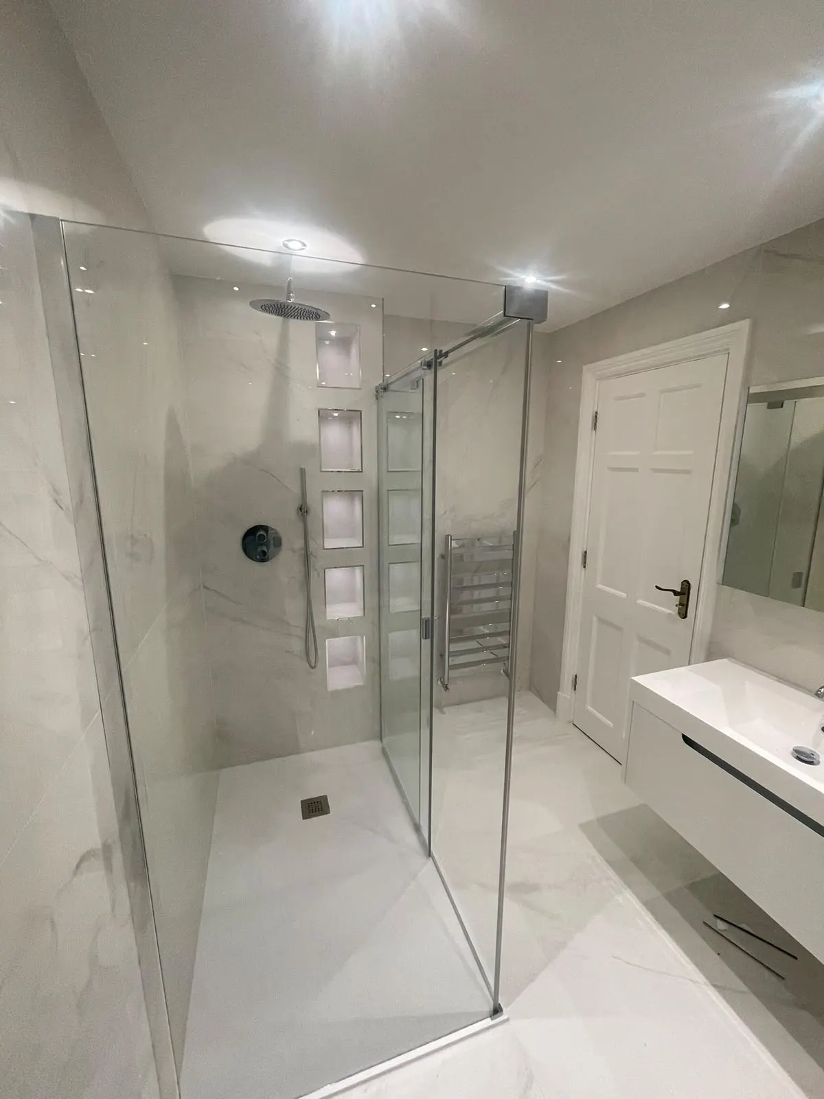 Bathroom renovation in London: shower enclosure, tiled niches and vanity