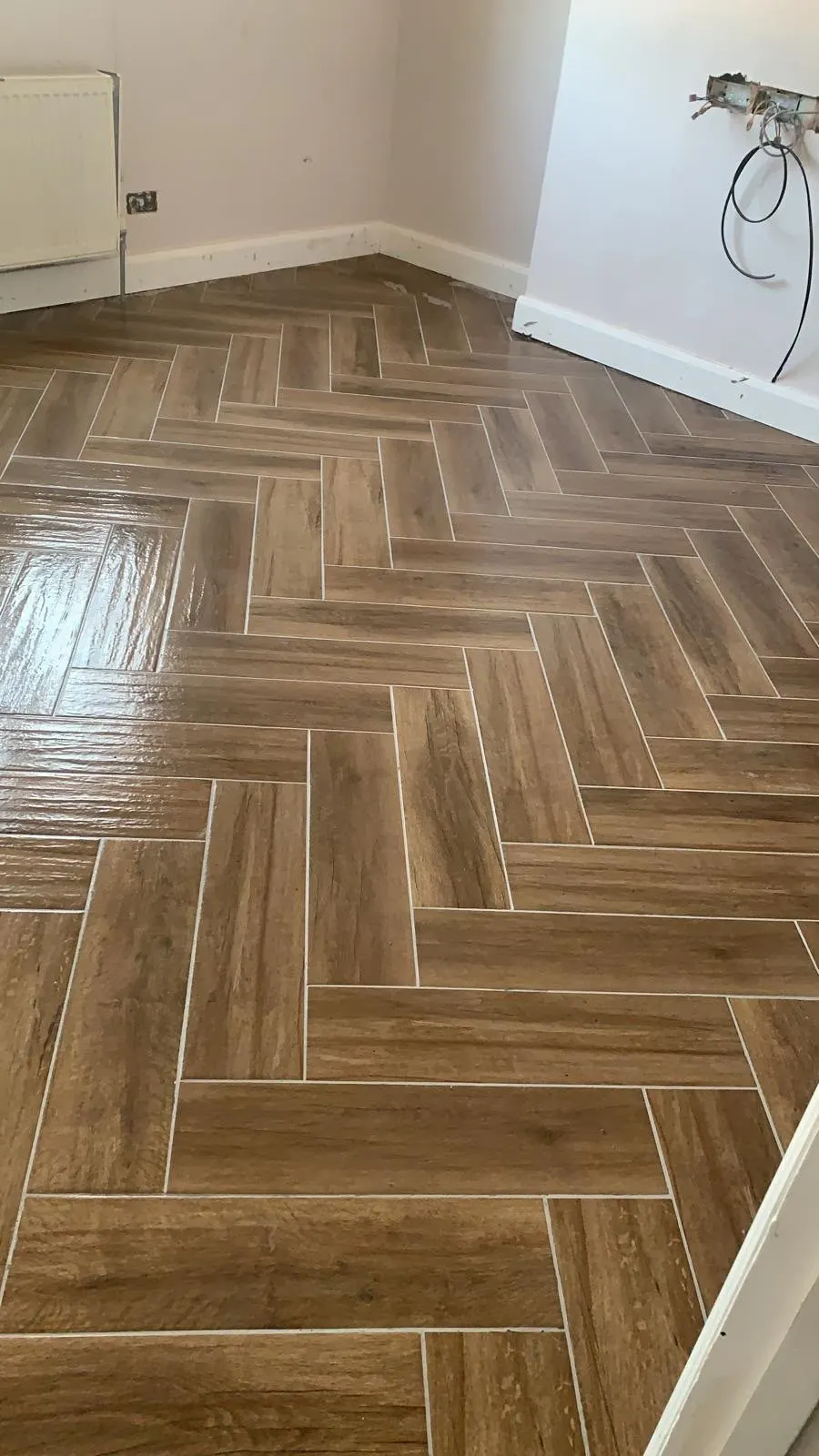 Floor and wall tiling in London: wood-effect herringbone porcelain floor tiles
