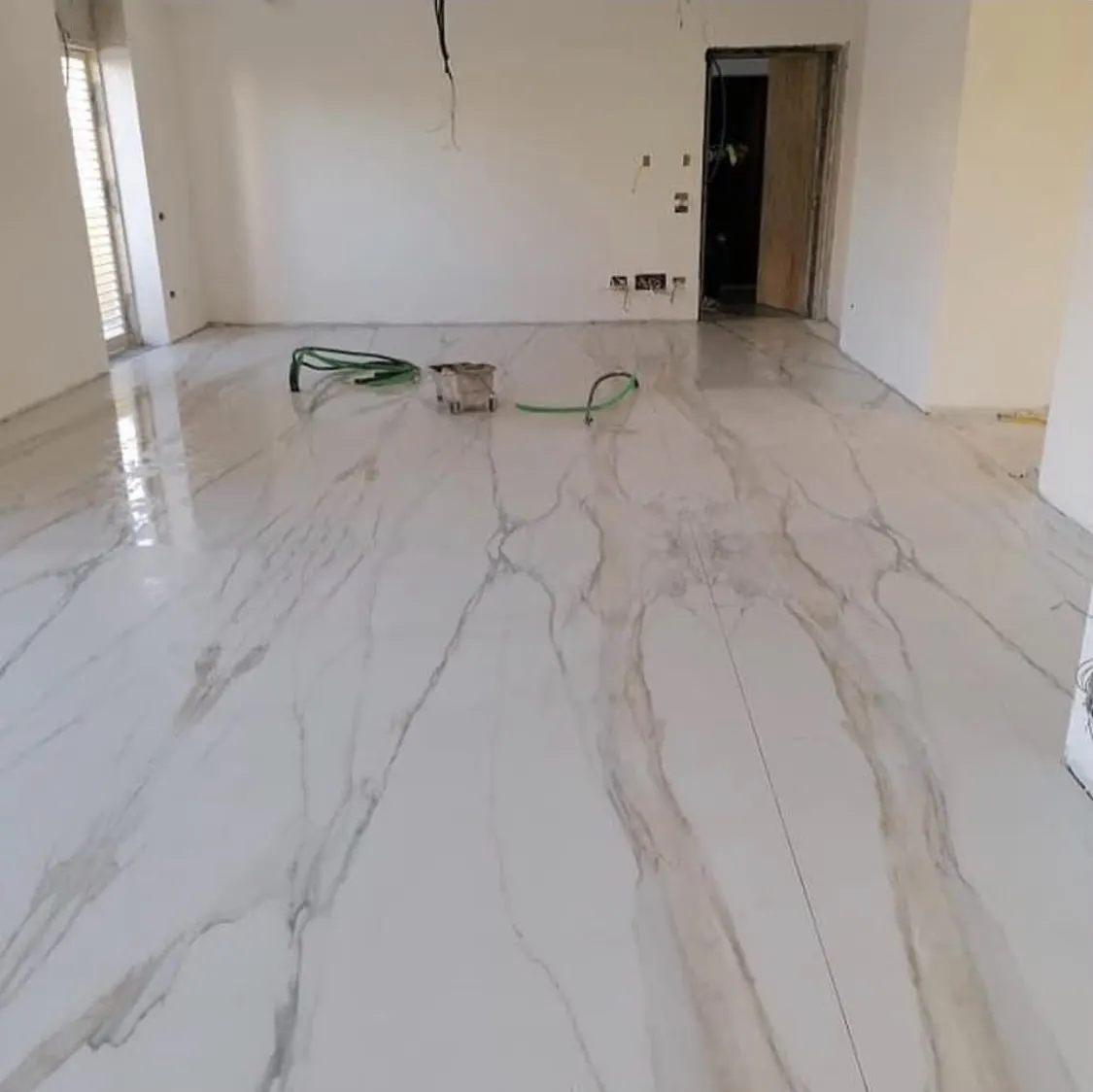 Floor and wall tiling in London: large-format book-matched marble-effect floor tiles
