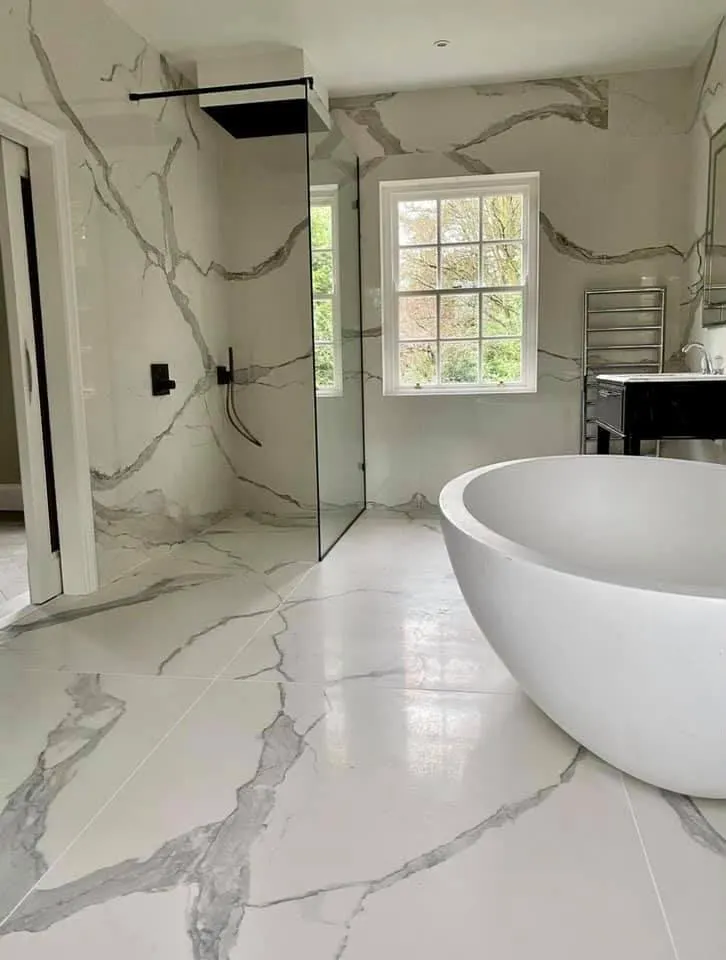 Bathroom renovation in London: marble-effect bathroom with freestanding oval bath and glass walk-in shower