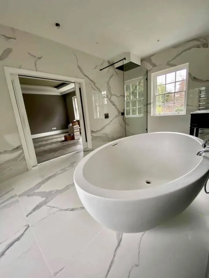 Bathroom renovation in London: veined marble-effect bathroom with freestanding bath