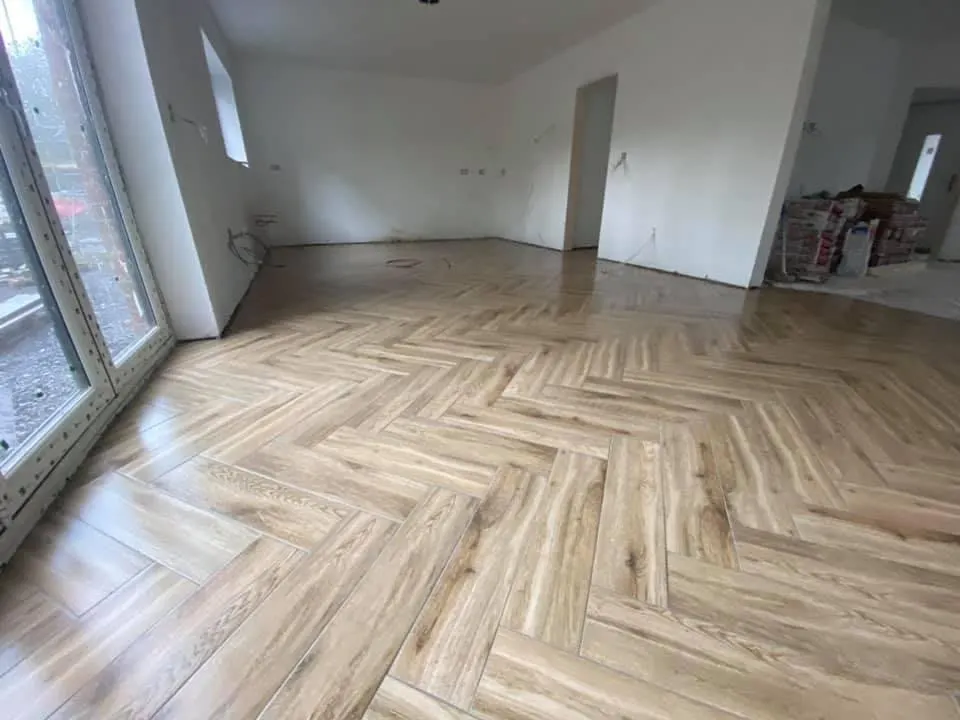 Floor and wall tiling in London: large wood-effect herringbone tiled floor