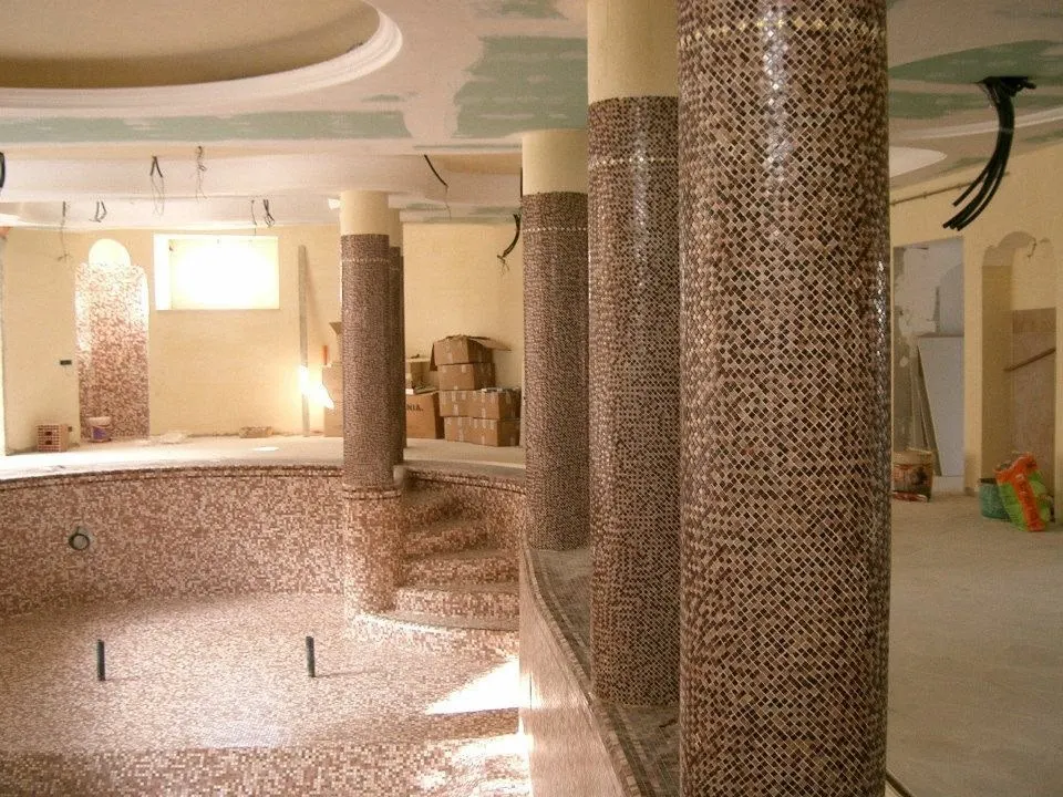 Floor and wall tiling in London: mosaic-tiled columns and pool basin