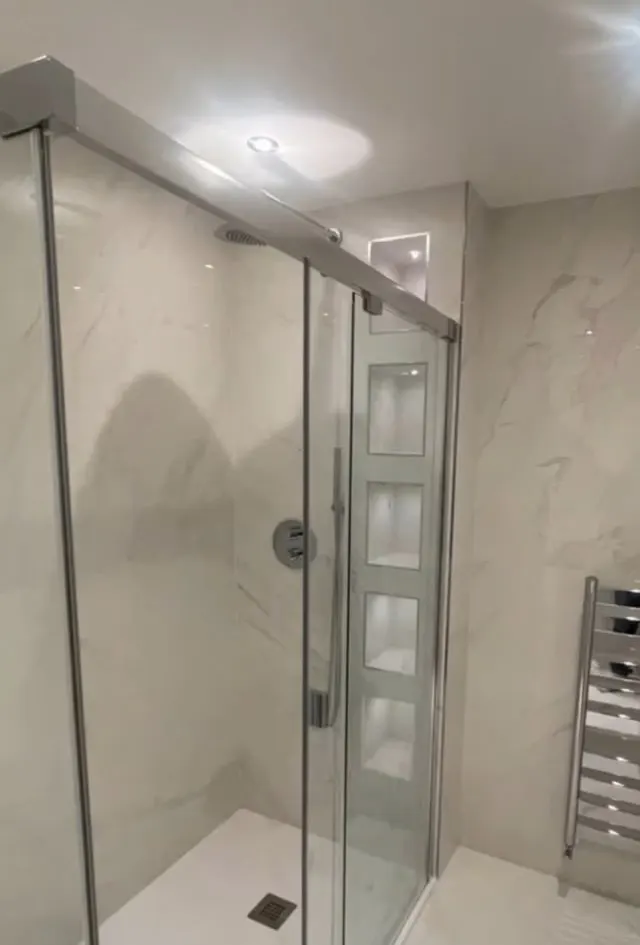Bathroom renovation in London: glass shower with recessed niches and heated towel rail