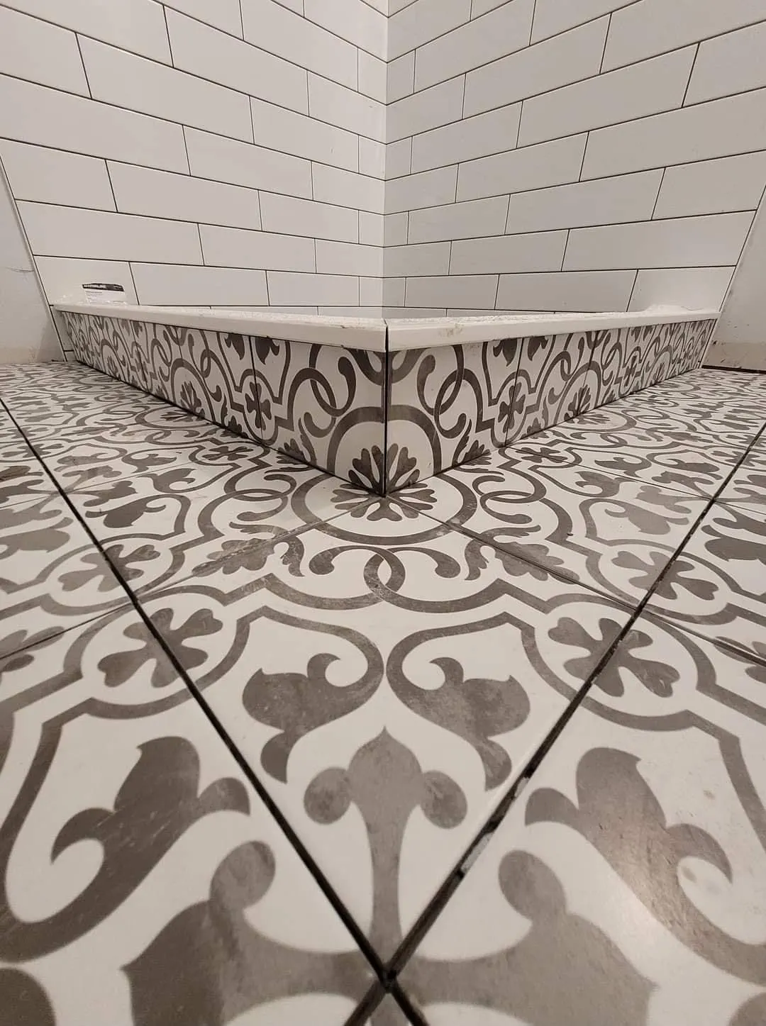 Floor and wall tiling in London: patterned encaustic-effect floor tiles with white metro walls