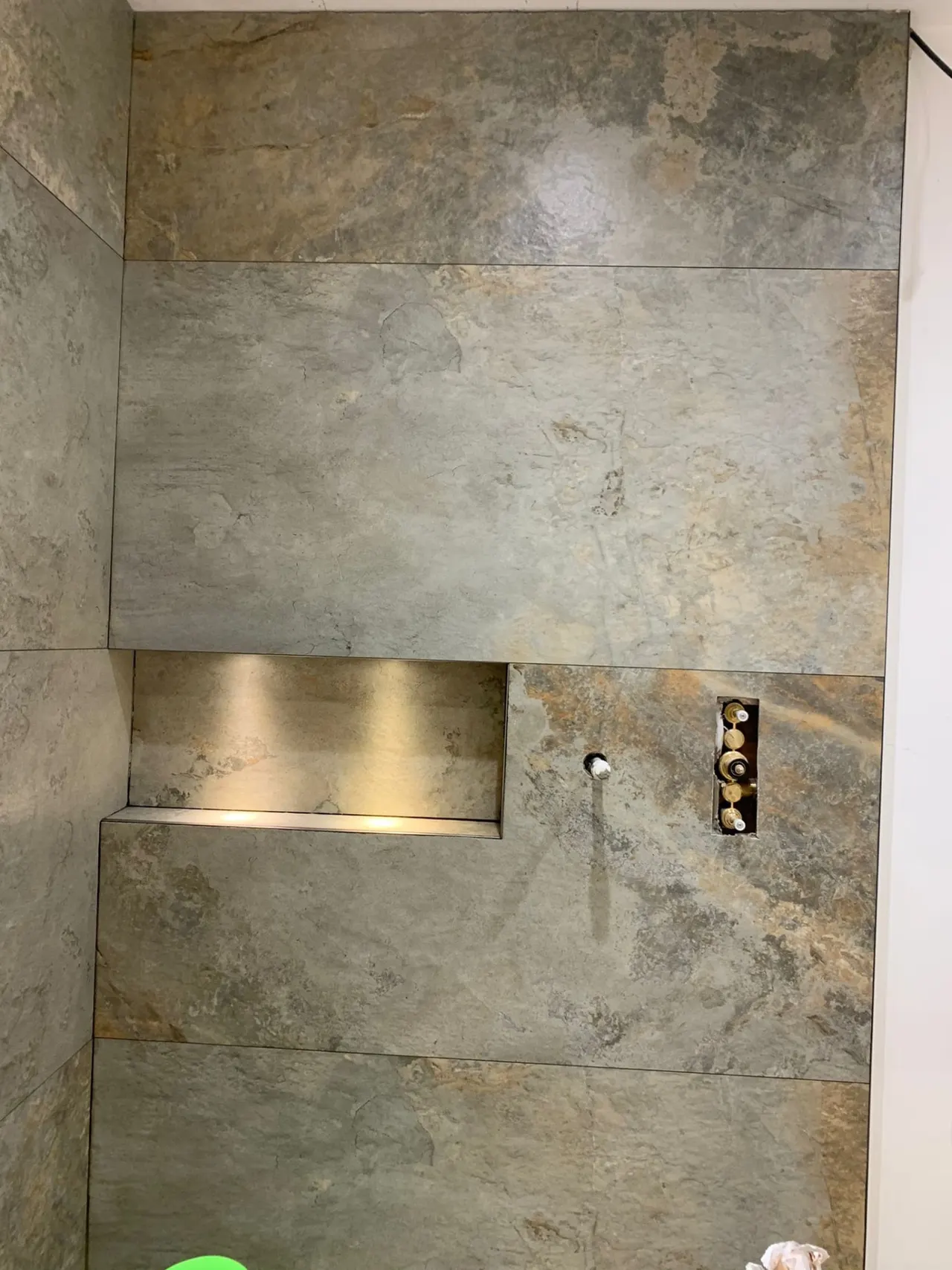 Bathroom renovation in London: stone-effect shower wall with recessed niche in progress