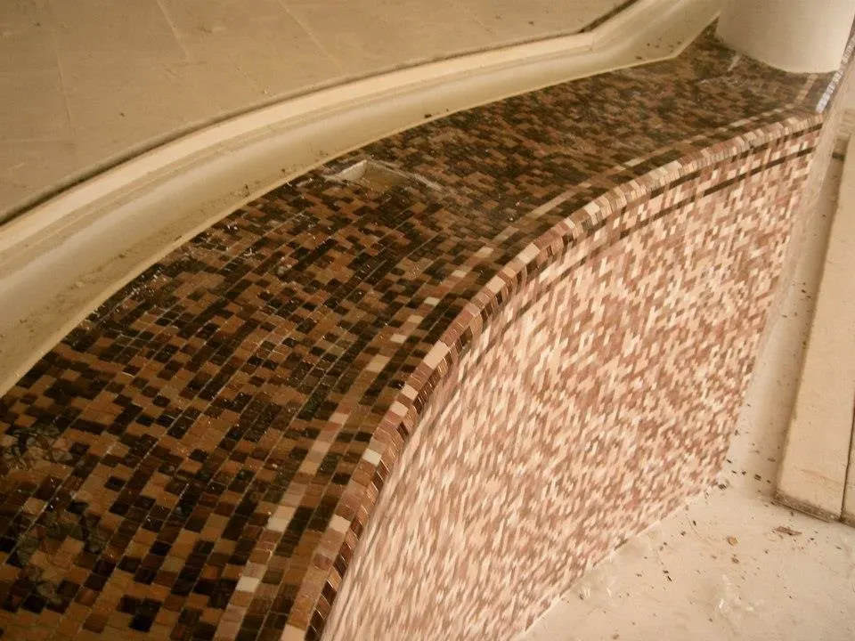 Floor and wall tiling in London: curved mosaic tiling on a pool edge
