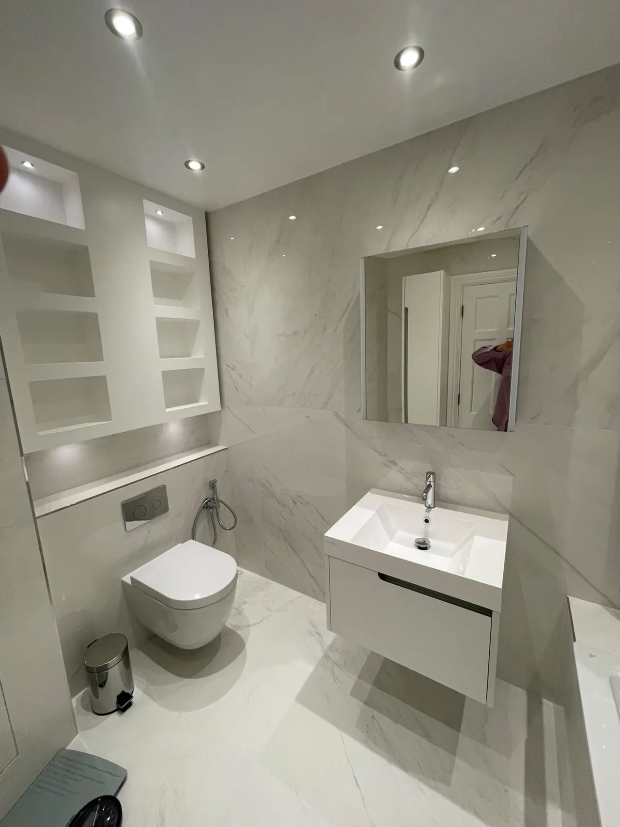 Bathroom renovation in London: wall-hung toilet and vanity with tiled recessed shelves